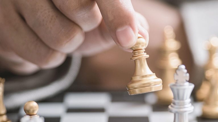 Close up of hand moving chess piece