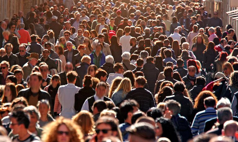 Image of large group of people crowding Rome's downtown streets in a sunny day.